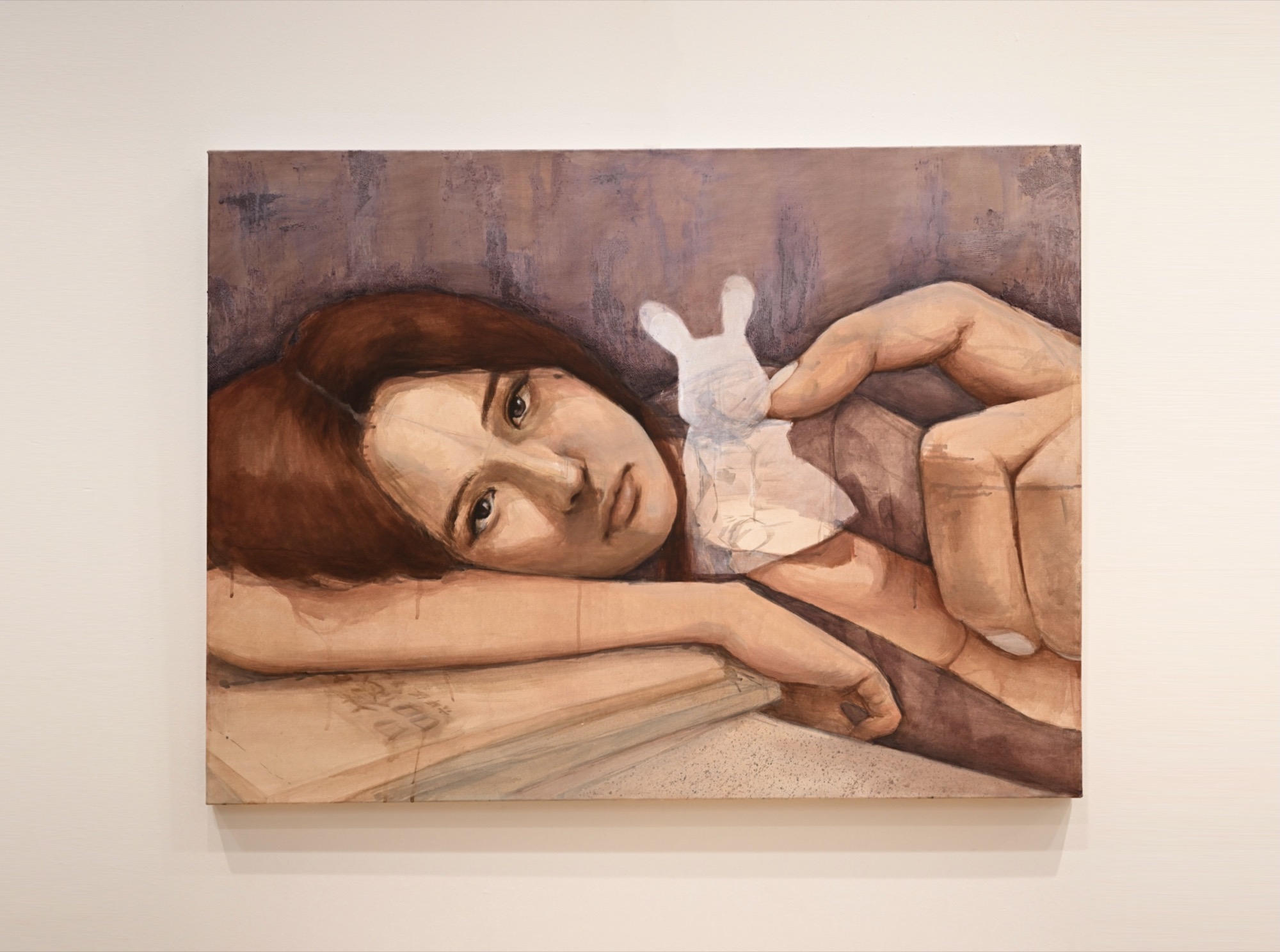 A painting of a reclining woman holding a small white rabbit figure