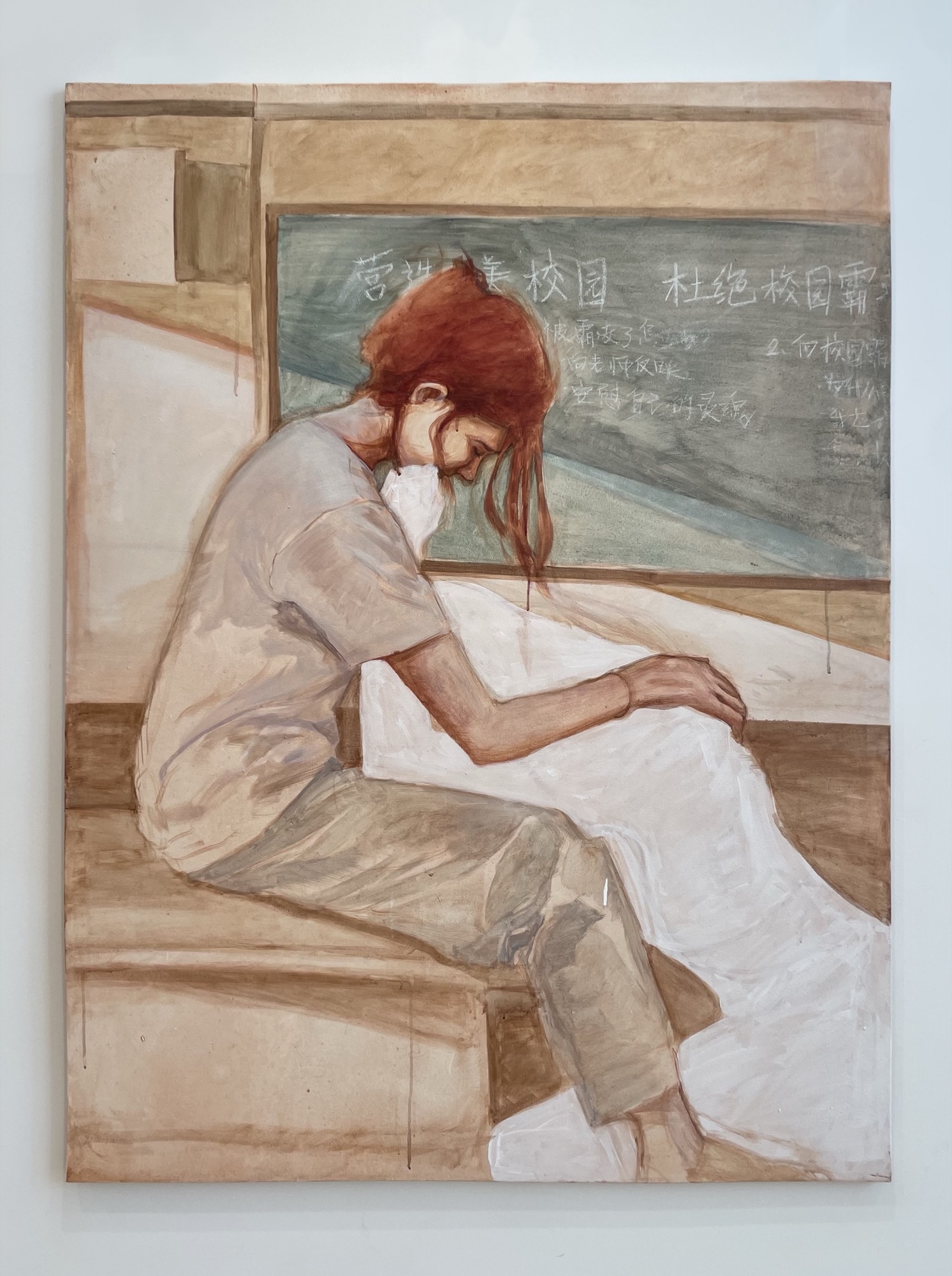 A large-scale painting of a red-haired figure seated in front of a chalkboard